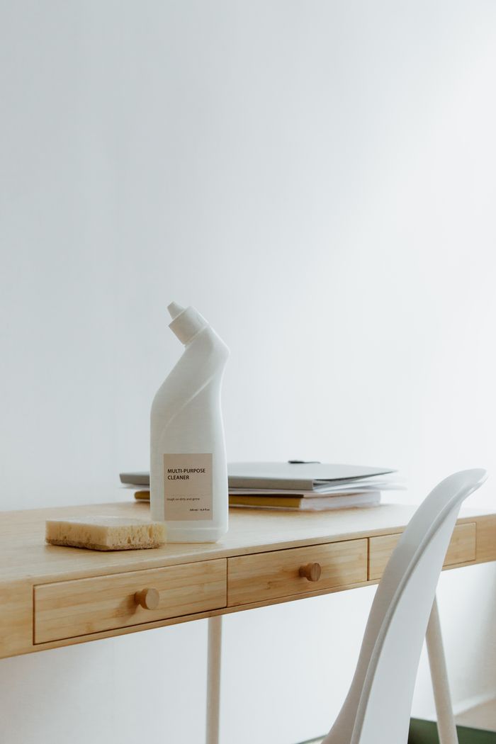hero-img-01 A tidy, well-arranged home office desk featuring a cleaner bottle and sponge, highlighting simplicity and practical use.